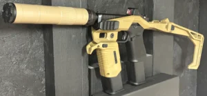 A tactical firearm with a tan stock and mounted sight is displayed against a textured black background.